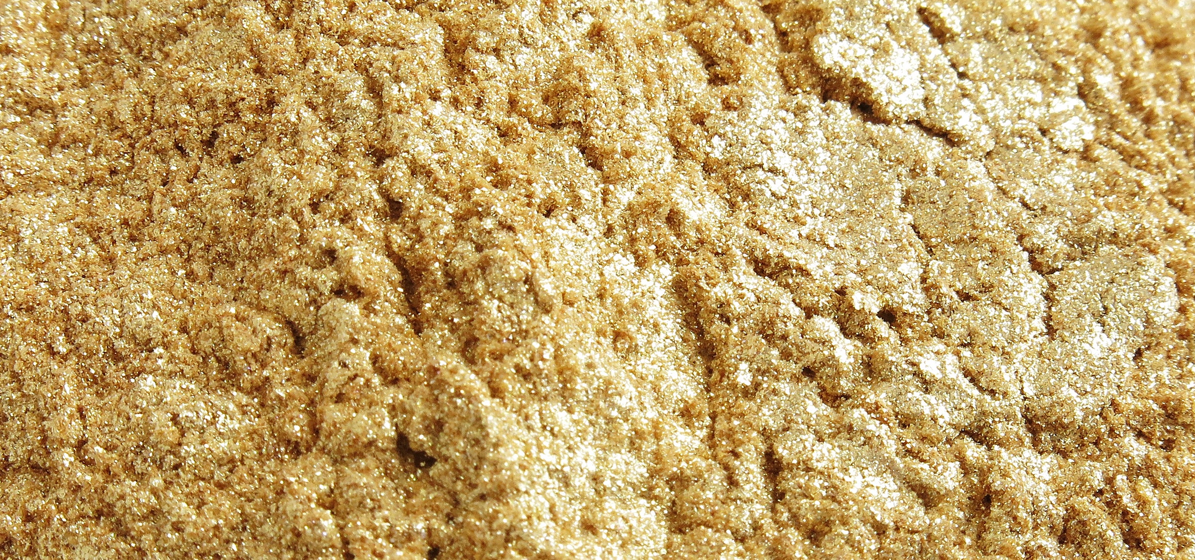 Feines goldgelbes Mica-Pulver auf weißem Hintergrund